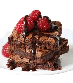 Chocolate brownies stacked with raspberries and chocolate sauce