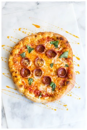 Hot Honey Pepperoni pizza with pepperoni, basil and a honey drizzle